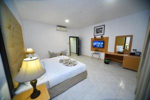 una camera d'albergo con letto e TV di Alain Hotel Apartments Ajman ad Ajman