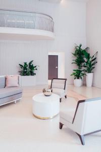 a living room with white furniture and potted plants at Cadillac Hotel & Beach Club, Autograph Collection in Miami Beach