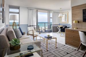 - un salon avec un canapé et une table dans l'établissement Cadillac Hotel & Beach Club, Autograph Collection, à Miami Beach