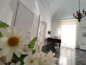 una habitación con flores blancas en una habitación con piano en Dimora della Marchesa - al Duomo, en Manfredonia