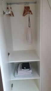 een witte kast met handdoeken, een tas en een tas bij Chambre d'hôtes confort et charme Paris 9eme in Parijs