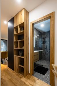 a bathroom with a walk in shower and a wooden door at Apartmán Nicole in Tale