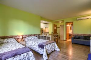 1 dormitorio con 2 camas y sala de estar en Apartamentos Barajas, en Madrid