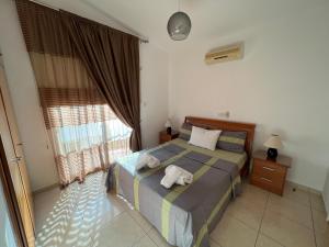 a bedroom with a bed and a large window at Three Bedroom Casa de Paphos in Paphos City