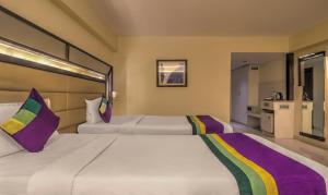 a hotel room with two beds and a kitchen at Treebo Tryst Metropolis in Hyderabad