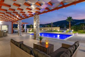 Villa Elite Kalathos by Villa Plus في كالاثوس: فناء في الهواء الطلق مع أريكة وحمام سباحة