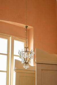 a chandelier hanging in a room with two windows at Palazzo Zacà in Gallipoli