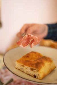 a person holding a piece of food on a plate at Palazzo Zacà in Gallipoli
