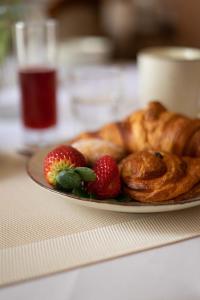 a plate with a pastry and strawberries on a table at Palazzo Zacà in Gallipoli