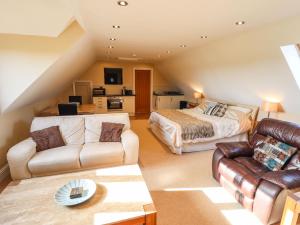 een woonkamer met een bed en een bank bij Granary Loft in Grantham