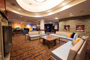 a hotel lobby with couches and tables and a fireplace at Courtyard by Marriott Halifax Downtown in Halifax
