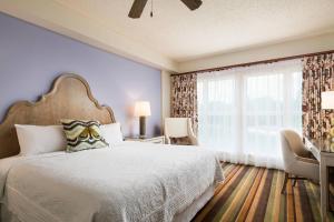 a bedroom with a bed and a large window at Celebration Hotel in Orlando