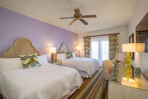 a bedroom with two beds and a ceiling fan at Celebration Hotel in Orlando