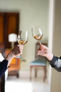 two people holding up glasses of white wine at Palazzo Zacà in Gallipoli
