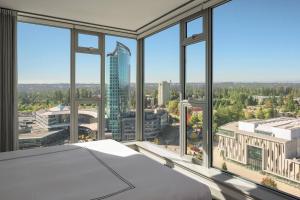a room with large windows with a view of a city at Civic Hotel, Autograph Collection in Surrey
