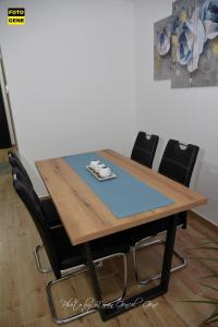 einen Esstisch mit schwarzen Stühlen um ihn herum in der Unterkunft Apartment No 11 in Subotica