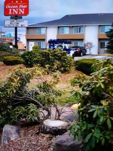 a building with a sign and bushes in front of it at Ocean Star Inn in Sequim