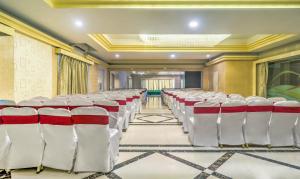 una sala de conferencias con sillas blancas y rojas en Treebo Tryst Metropolis, en Hyderabad
