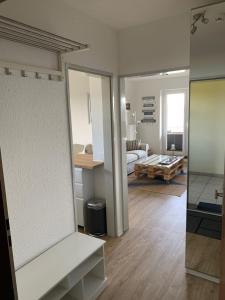 a living room with a large mirror and a bedroom at Apartment am See in Scharbeutz