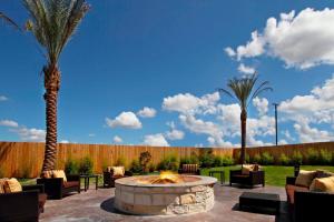 a patio with a fire pit and two palm trees at Courtyard by Marriott Victoria in Victoria