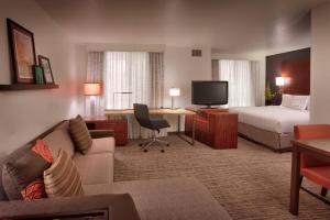 a hotel room with a couch and a bed and a television at Residence Inn Salt Lake City Sandy in Sandy