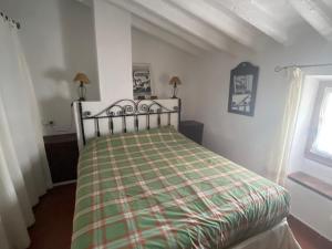 Un dormitorio con una cama con una manta a cuadros. en Beautiful Traditional town house, en Ardales