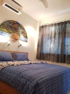 a bedroom with a blue bed and a window at House in Ban Phe, Thailand in Rayong