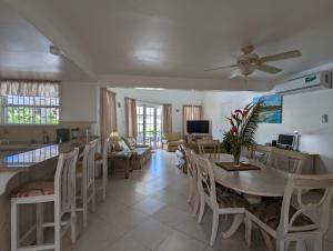 a dining room and living room with a table and chairs at Vida Mejor - West Pool in Saint James