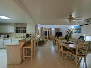 a kitchen and living room with a table and chairs at Vida Mejor - West Pool in Saint James
