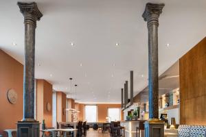 two columns in a restaurant with tables and chairs at AC Hotel Palacio Universal by Marriott in Vigo