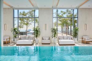 una piscina de hotel con muebles blancos y ventanas en The Pearle Hotel & Spa, Autograph Collection, en Burlington