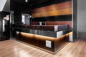 a lobby with a bar with black walls and wooden floors at AC Hotel Palacio Universal by Marriott in Vigo