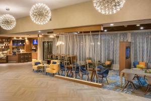 um átrio de um hotel com mesas, cadeiras e lustres em Marriott Tampa Westshore em Tampa