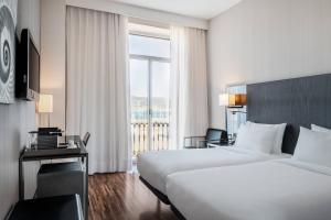 a hotel room with two beds and a window at AC Hotel Palacio Universal by Marriott in Vigo