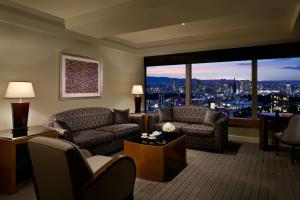 a living room with a couch and chairs and a large window at The Ritz-Carlton, Tokyo in Tokyo
