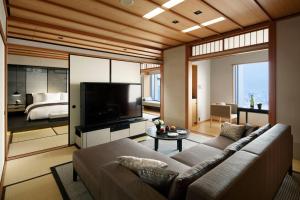 a living room with a couch and a flat screen tv at The Ritz-Carlton, Tokyo in Tokyo