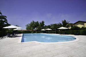 a swimming pool with chairs and umbrellas at Hotel Tenuta San Francesco in Barletta