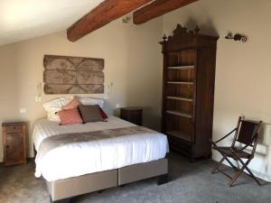 a bedroom with a bed and a wooden cabinet at Mas Allard in Tarascon