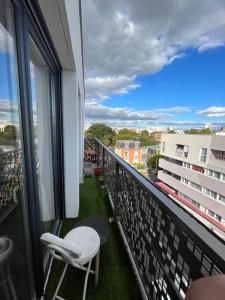 balcón con 2 sillas y vistas a un edificio en Appartement Nanterre, en Nanterre