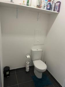 baño con aseo blanco y estante en Appartement Nanterre, en Nanterre