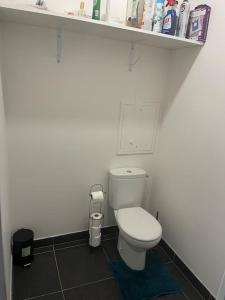 a bathroom with a white toilet and a shelf at Appartement Nanterre in Nanterre