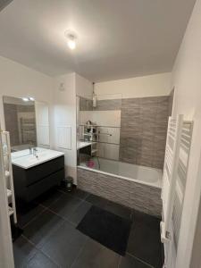 y baño con bañera, lavamanos y bañera. en Appartement Nanterre, en Nanterre