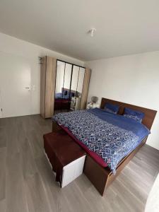 1 dormitorio con 1 cama grande y edredón azul en Appartement Nanterre, en Nanterre