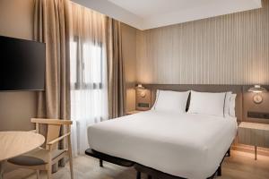 a bedroom with a large white bed and a table at AC Hotel by Marriott Tenerife in Santa Cruz de Tenerife +34 photos