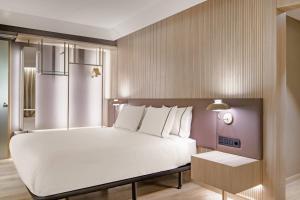 a bedroom with a large white bed and a table at AC Hotel by Marriott Tenerife in Santa Cruz de Tenerife