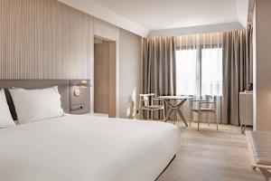 a hotel room with a large bed and a table at AC Hotel by Marriott Tenerife in Santa Cruz de Tenerife