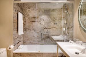a bathroom with a shower and a tub and a sink at AC Hotel by Marriott Tenerife in Santa Cruz de Tenerife