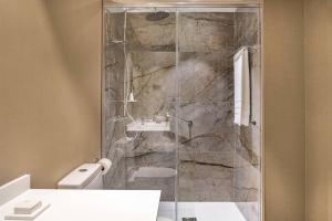 a bathroom with a shower with a toilet and a sink at AC Hotel by Marriott Tenerife in Santa Cruz de Tenerife