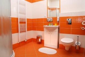 un bagno arancione con servizi igienici e lavandino di Hotel U Zlatého býka a Písek