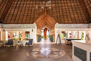 um átrio de um resort com uma mesa e cadeiras em Margaritaville Island Reserve Riviera Cancún - An All-Inclusive Experience for All em Puerto Morelos